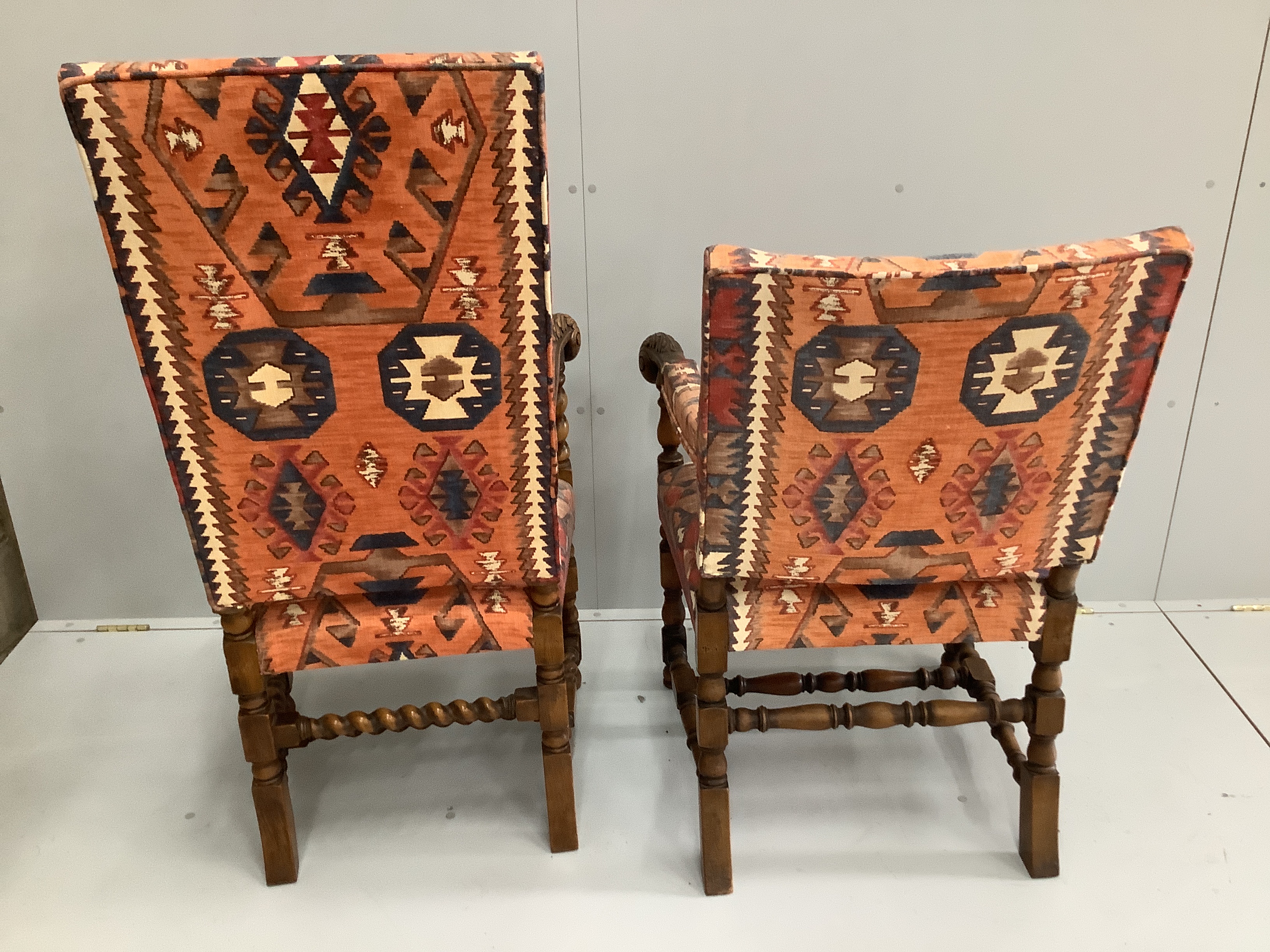 Two 1920's Jacobean Revival carved walnut elbow chairs with Kilim fabric upholstery, larger width 65cm, depth 50cm, height 124cm